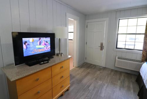 a bedroom with a flat screen tv on a dresser at Bishop Inn Downtown Gatlinburg in Gatlinburg