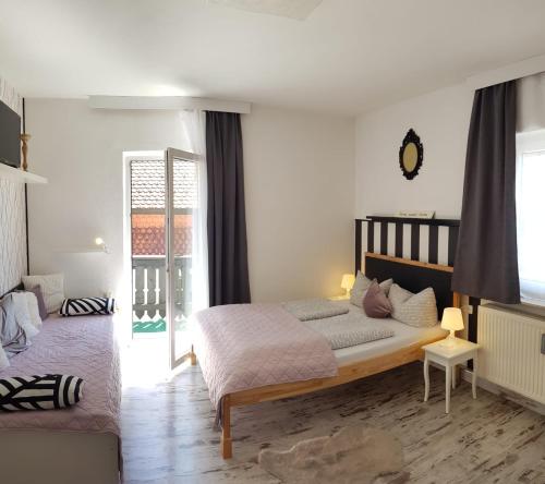 a bedroom with a bed and a window at LA Boutique House in Füssen