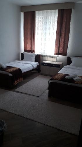 a bedroom with two beds and a window at Apartmani Ambiente in Plav