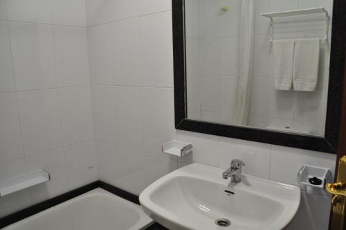 biała łazienka z umywalką i lustrem w obiekcie Hotel Casa Portuguesa w mieście Meaño