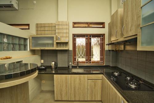 a kitchen with black counter tops and a window at Dalai Home in Kuta Lombok