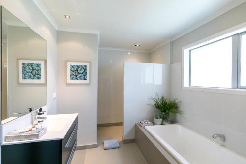 a bathroom with a large tub and a window at Spacious Modern Two-Bedroom Apartment in Hamilton