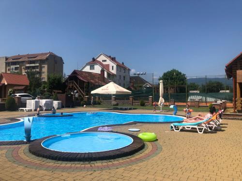 a large swimming pool with people sitting around it at Рутенія in Svalyava