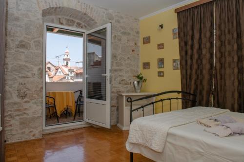 a small bedroom with a bed and a balcony at Devivi Apartments in Split