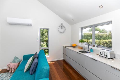 a kitchen with a blue couch and a sink at Spacious Modern Two-Bedroom Apartment in Hamilton