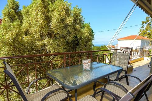 a table and chairs on the balcony of a house at Aristotelis Apartment Lakithra-Alexandra in Lakithra