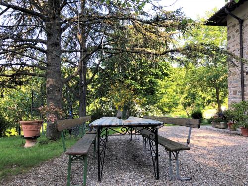 a picnic table and two benches in a park at Podere Badia Valdrago Agriturismo Mugello Circuit in Scarperia