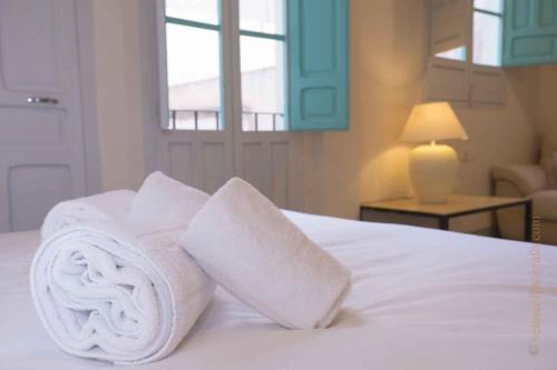 a pile of towels sitting on top of a bed at Vintage & Cosy Auditorium in Alicante