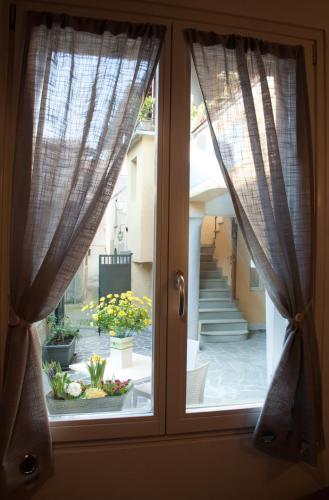 a window with curtains looking out at a garden at La Casa del Comandante in Sulzano