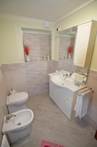 a bathroom with a sink and a toilet and a mirror at Casa Maria in Camaiore