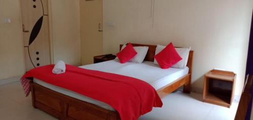 a bedroom with a bed with a red blanket on it at Pokhrel Lodge in Kalimpong