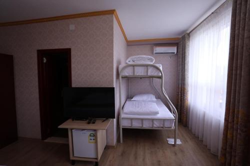 a small room with a bunk bed and a tv at British Hotel Pogradec in Pogradec