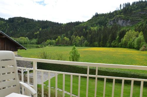 a white porch with a view of a green field at Ferien am Talhof in Sankt Urban