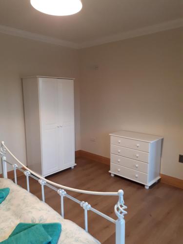 um quarto com uma cama, uma cómoda e um armário em Country house em Galway