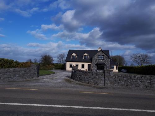 a house on the side of a stone wall at Country house in Galway