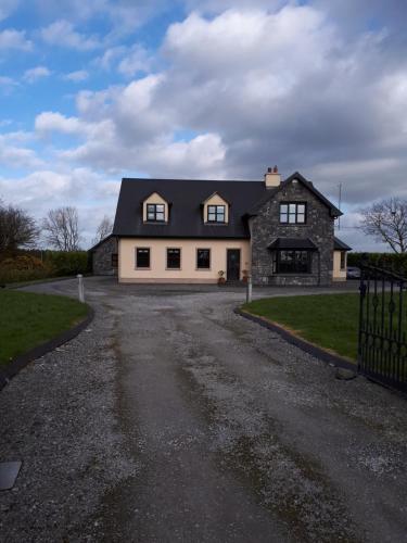 a large black and white house with a driveway at Country house in Galway