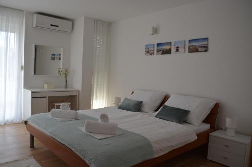 a bedroom with a bed with two towels on it at Villa Antea - modern house with pool in Pag