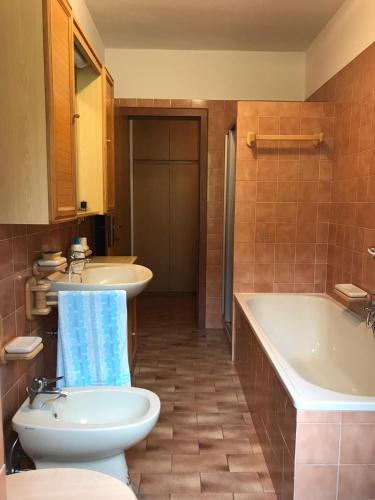 a bathroom with a tub and a toilet and a sink at Appartamento Pezzol in Daiano