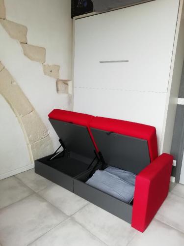 a red bench sitting in the corner of a room at La Villa Tria Castella in Saint-Paul-Trois-Châteaux