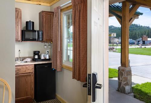 a kitchen with a black dishwasher next to a window at Rock Crest Lodge & Cabins in Custer