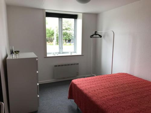 a bedroom with a red bed and a window at BB-Vadehavet Ferielejlighed til 6 personer ved Nationalpark Vadehavet in Ribe