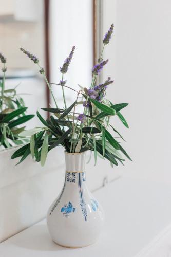 a blue and white vase with purple flowers in it at Afroditi Pansion in Agios Nikitas