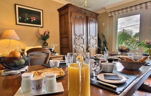 a dining room table with a glass of orange juice at Les Chambres de Kermenguy in Sibiril