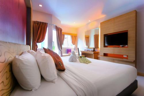 A bed or beds in a room at Andatel Grande Patong Phuket