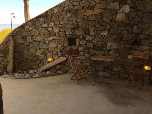 a stone building with a stone fireplace and chairs at Scorpio house 180 sea view - Serifians Residences in Serifos Chora