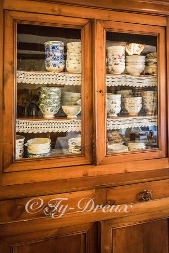 a wooden cabinet with dishes in it at ty dreux entre terre et mer in Saint-Thégonnec