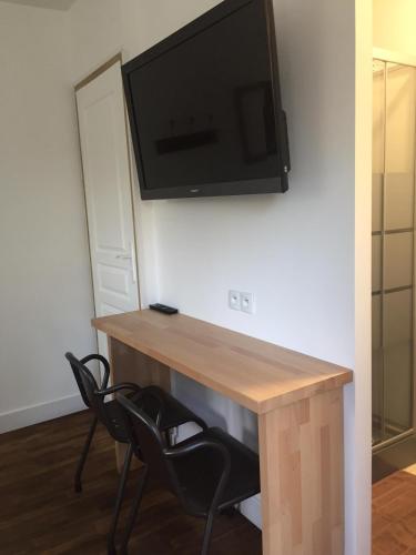 - un bureau avec deux chaises et une télévision murale dans l'établissement La Jackal, à Ploubezre