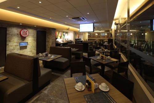 a restaurant with tables and chairs and a television at Casa Andina Select Chiclayo in Chiclayo