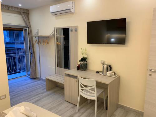 a room with a desk and a television on the wall at B&B In Centro in Crotone