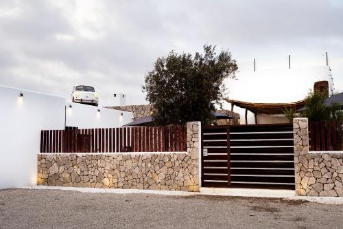 a fence with a gate and a stone wall at PAIISE Hotels in Sant Francesc de s'Estany