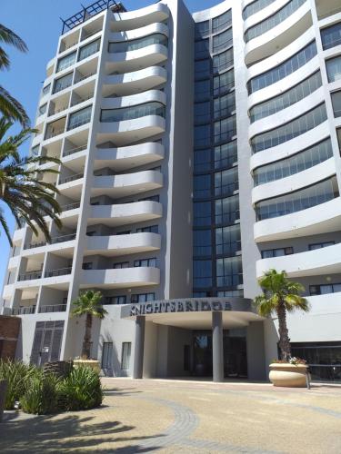 a building with palm trees in front of it at Home relaxation in the city in Cape Town
