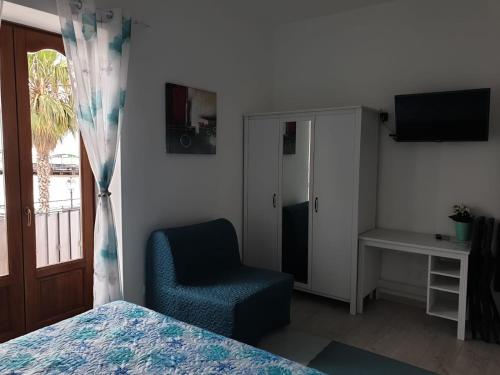 a bedroom with a bed and a chair and a television at Deluxe Lipari Room in Lipari