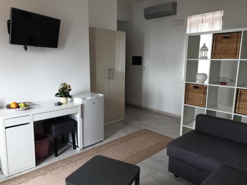 een woonkamer met een bureau en een bank bij Deluxe Lipari Room in Lipari
