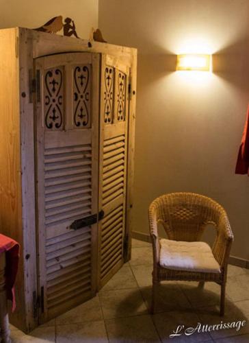 a room with a chair and a door and a lamp at L'Atterrissage in Santes