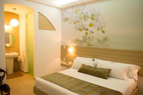 a bedroom with a bed and a painting of flowers at Grand Hotel Tepatitlán in Tepatitlán de Morelos