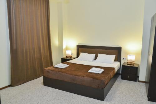 a bedroom with a large bed with two night stands at Hotel Garden in Tbilisi City