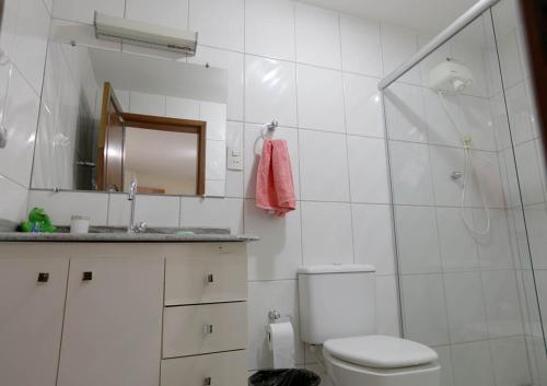 a white bathroom with a toilet and a shower at Recanto São Francisco, Casa 2 quartos 100m Igreja São Francisco Pet friend in São João del Rei