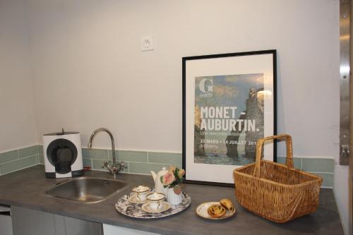 a kitchen counter with a sink and a picture at Belle Vue Terrasse in Giverny