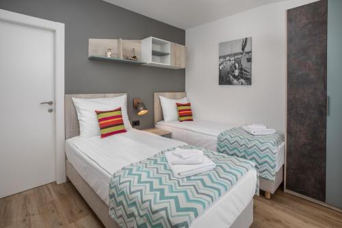 two beds in a small room with white walls at Holiday Homes Kanajt in Punat