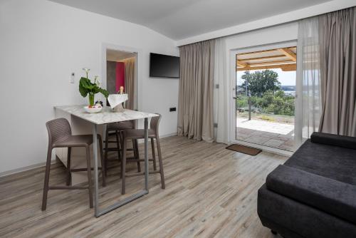 a kitchen and living room with a table and chairs at Holiday Homes Kanajt in Punat