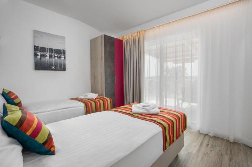 a bedroom with two beds and a window at Holiday Homes Kanajt in Punat