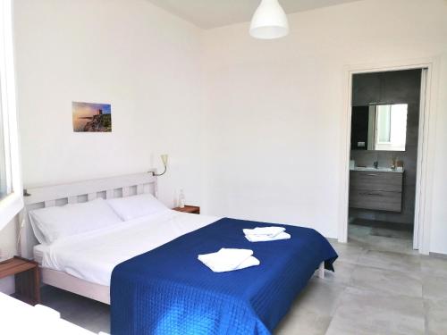 a bedroom with a bed with a blue blanket at DoppioBi in Torre Lapillo