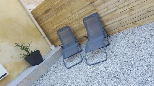 duas cadeiras pretas sentadas ao lado de um edifício em Gîte O'Cigales em Sablet