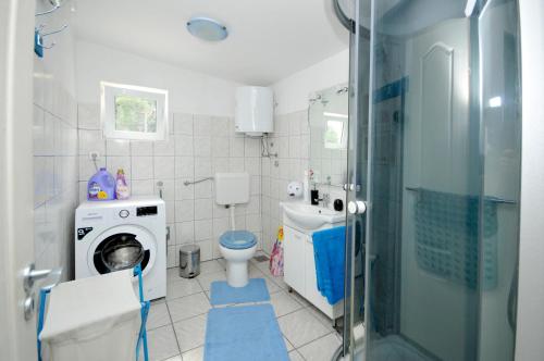 bagno con lavandino e servizi igienici e lavatrice. di Apartment Sandra a Trogir