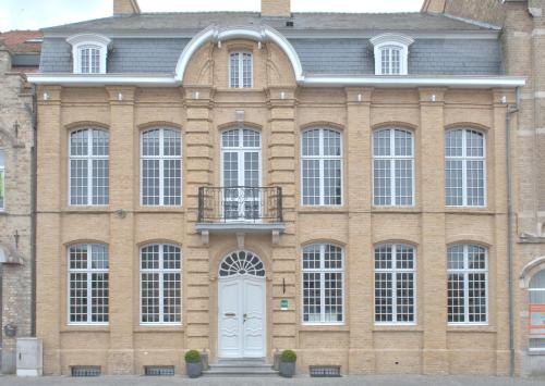 a large brick building with a white door at B&B 't Withuis in Diksmuide