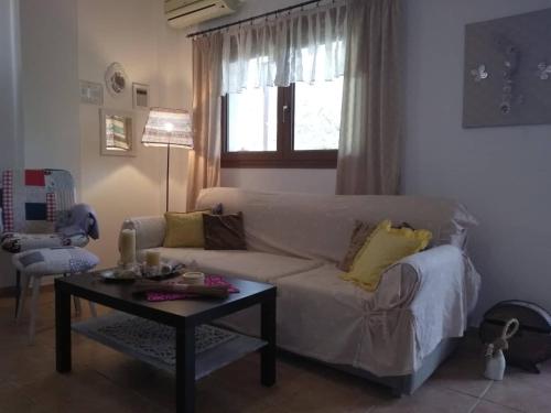een woonkamer met een witte bank en een tafel bij Golden Vali House in Koinira